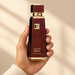 French Avenue Liquid Brun Limited Edition 150 ml: Hand holding the tall burgundy bottle with gold trim