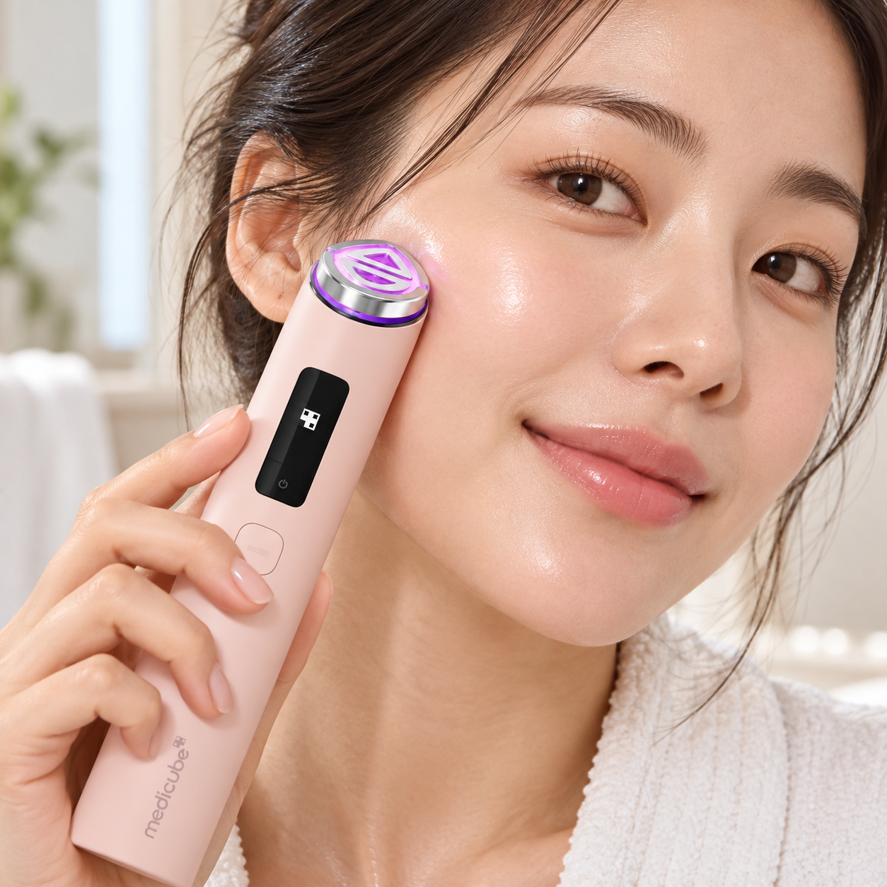 Model using the pink Medicube AGE-R Booster Pro X2 facial device.