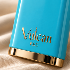 French Avenue Vulcan Feu 100 ml: Close-up of gold Vulcan Feu lettering on the turquoise bottle resting on beige fabric