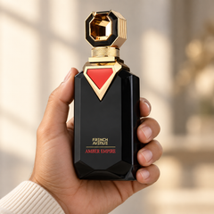 French Avenue Amber Empire 100 ml: Hand holding the black bottle with a gold stopper and red triangle